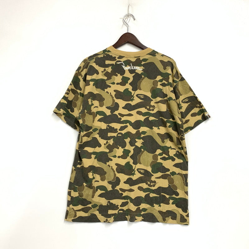 【中古品】【メンズ】 A BATHING APE アベイシングエイプ × KAWS カウズ 1ST CAMO BAPE LOGO S S TEE カモ ベイプ ロゴ ショートスリーブ Tシャツ トップス 半袖 142-260724-ya-10-izu サイズ：L カラー：ベージュ系 万代Net店
