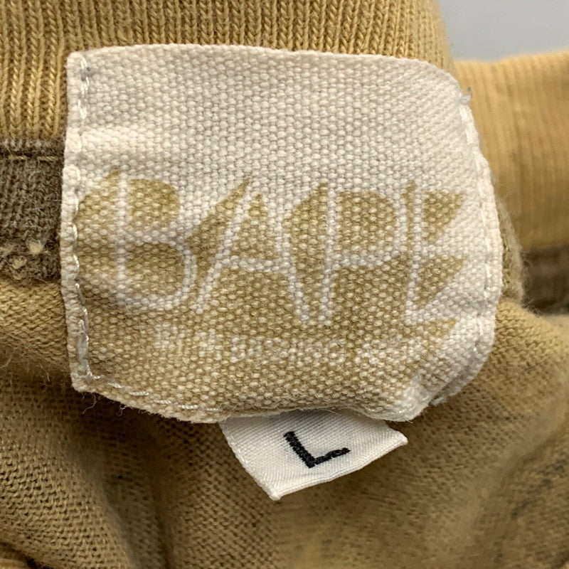 【中古品】【メンズ】 A BATHING APE アベイシングエイプ × KAWS カウズ 1ST CAMO BAPE LOGO S S TEE カモ ベイプ ロゴ ショートスリーブ Tシャツ トップス 半袖 142-260724-ya-10-izu サイズ：L カラー：ベージュ系 万代Net店