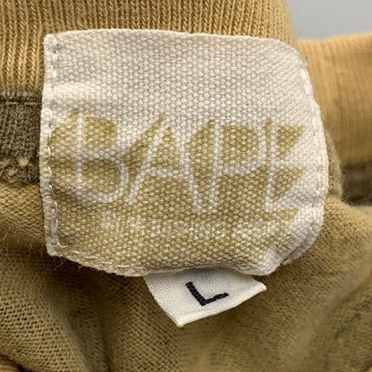【中古品】【メンズ】 A BATHING APE アベイシングエイプ × KAWS カウズ 1ST CAMO BAPE LOGO S S TEE カモ ベイプ ロゴ ショートスリーブ Tシャツ トップス 半袖 142-260724-ya-10-izu サイズ：L カラー：ベージュ系 万代Net店