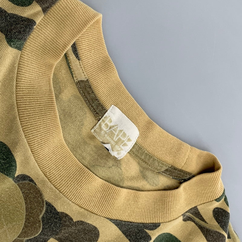 【中古品】【メンズ】 A BATHING APE アベイシングエイプ × KAWS カウズ 1ST CAMO BAPE LOGO S S TEE カモ ベイプ ロゴ ショートスリーブ Tシャツ トップス 半袖 142-260724-ya-10-izu サイズ：L カラー：ベージュ系 万代Net店