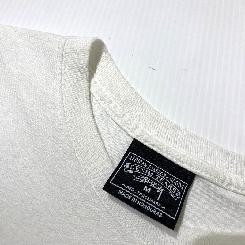 【中古品】【メンズ】 STUSSY ステューシー × DENIM TEARS デニムティアーズ 別注コラボ ANNIE LEE TEE アニーリー Tシャツ 半袖 トップス 142-260831-yo-03-tei サイズ：M カラー：ホワイト 万代Net店